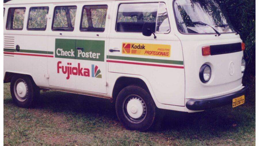 Kombi branca com logotipos do Fujioka. Imagem com aspecto dos anos 80.